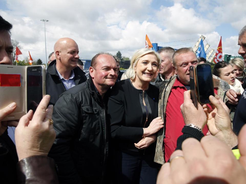 French far-right Front National (FN) presidential election candidate, Marine Le Pen, poses for selfies with strike employees of Whirlpool, in Amiens, France (Chesnot/Getty)