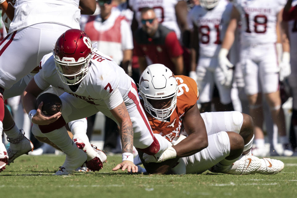 Oklahoma quarterback Spencer Rattler (7) is sacked by Texas defensive lineman Alfred Collins (95) during the first half of an NCAA college football game at the Cotton Bowl, Saturday, Oct. 9, 2021, in Dallas. (AP Photo/Jeffrey McWhorter)