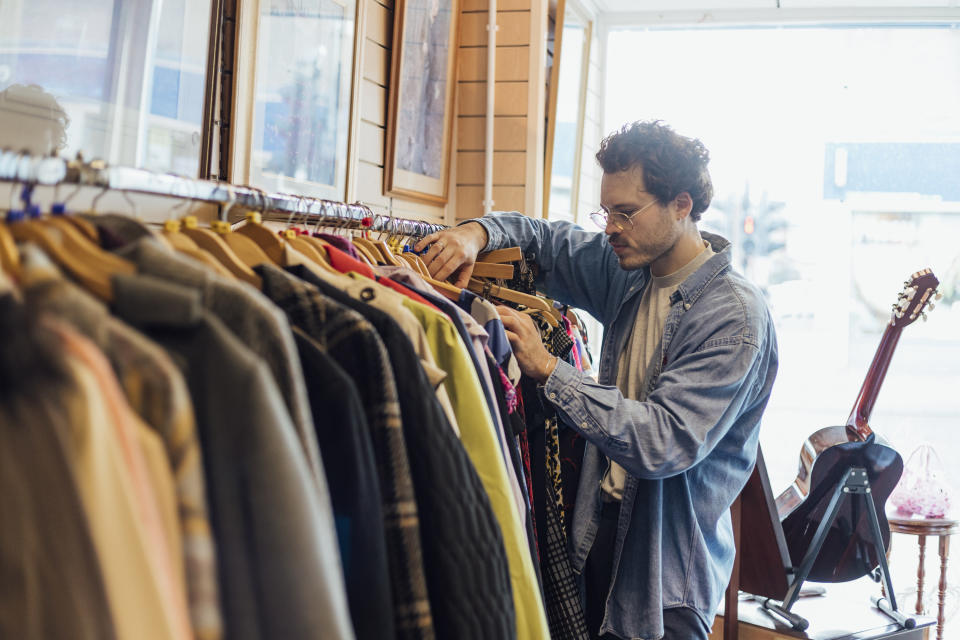 person looking through clothing at a thrift store