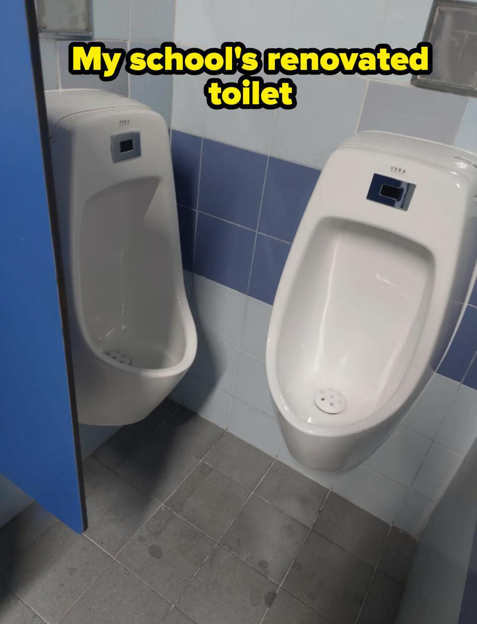 Two standard white urinals are installed side by side in a tiled public restroom. The restroom has light blue and white tiles