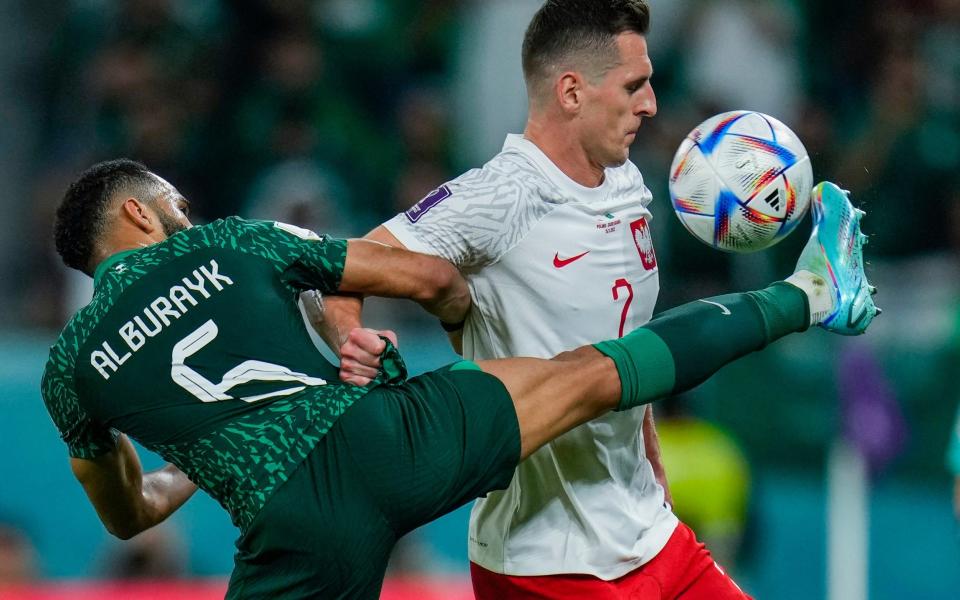 Saudi Arabia's Ali Al-Bulaihi, left, and Poland's Matty Cash fight for the ball during the World Cup group C soccer match between Poland and Saudi Arabia, at the Education City Stadium in Al Rayyan , Qatar, Saturday, Nov. 26, 2022 - AP Photo/Manu Fernandez