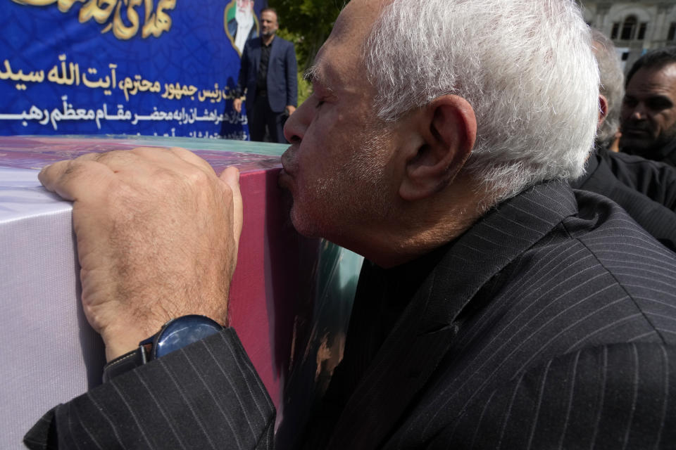 Former Iranian Foreign Minister Mohammad Javad Zarif kisses the flag-draped coffin of the late Foreign Minister Hossein Amirabdollahian, who was killed in a helicopter crash along with President Ebrahim Raisi on Sunday in a mountainous region of the country's northwest, during a funeral ceremony at the foreign ministry in Tehran, Iran, Thursday, May 23, 2024. The death of Raisi, Foreign Minister Hossein Amirabdollahian and six others in the crash on Sunday comes at a politically sensitive moment for Iran, both at home and abroad.(AP Photo/Vahid Salemi)