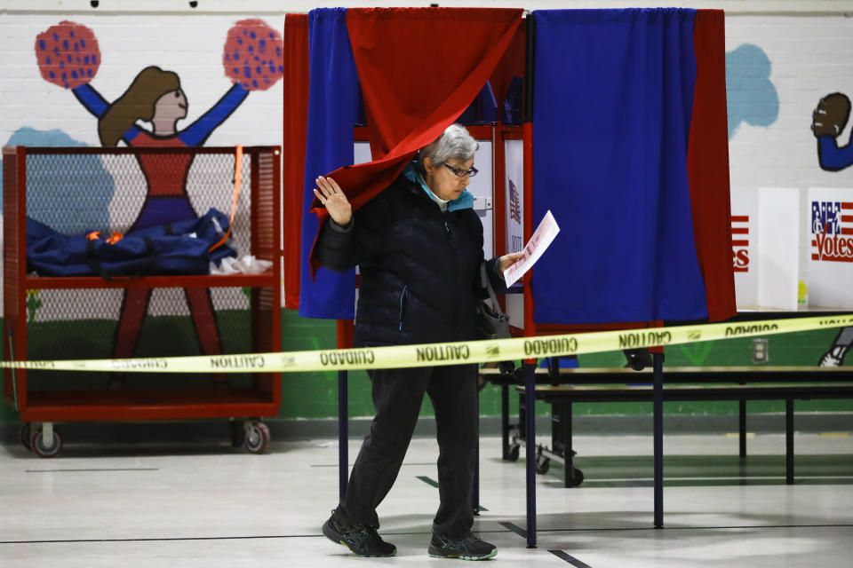A voter steps from a booth after casting a ballot in the New Hampshire primary, Tuesday, Feb. 11, 2020, in Manchester, N.H. (AP Photo/Matt Rourke)