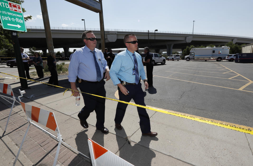 Denver Police Department detectives walk through a parking lot near the scene of a triple homicide south of downtown Denver, Thursday, Aug. 9, 2018. Police are trying to determine if the deaths of three homeless people are related to an earlier stabbing in the area. (AP Photo/David Zalubowski)