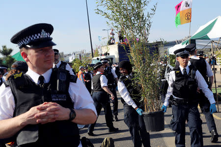 Police officers remove a plant during the Extinction Rebellion protest on Waterloo Bridge in London, Britain April 20, 2019. REUTERS/Simon Dawson