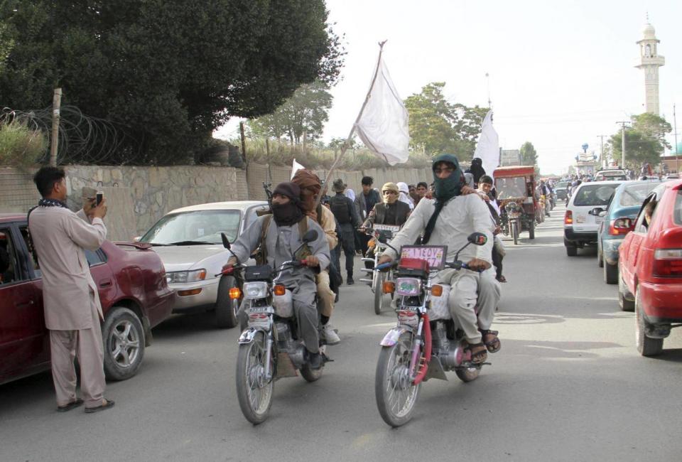 Taliban fighters ride their motorbikes inside Ghazni city (AP Photo)