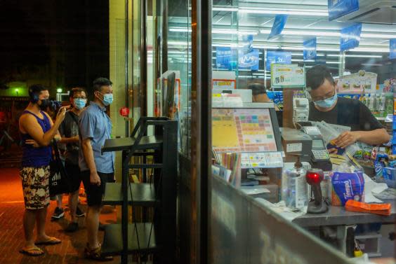 Hong Kongers queue outside a shop selling Apple Daily in the early hours of Tuesday morning (Getty)