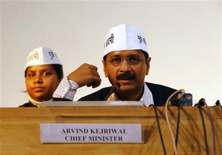 Arvind Kejriwal (R), leader of Aam Aadmi (Common Man) Party, speaks during a meeting with his party leaders and media personnel after taking the oath as the new chief minister of Delhi, in New Delhi December 28, 2013. REUTERS/Anindito Mukherjee