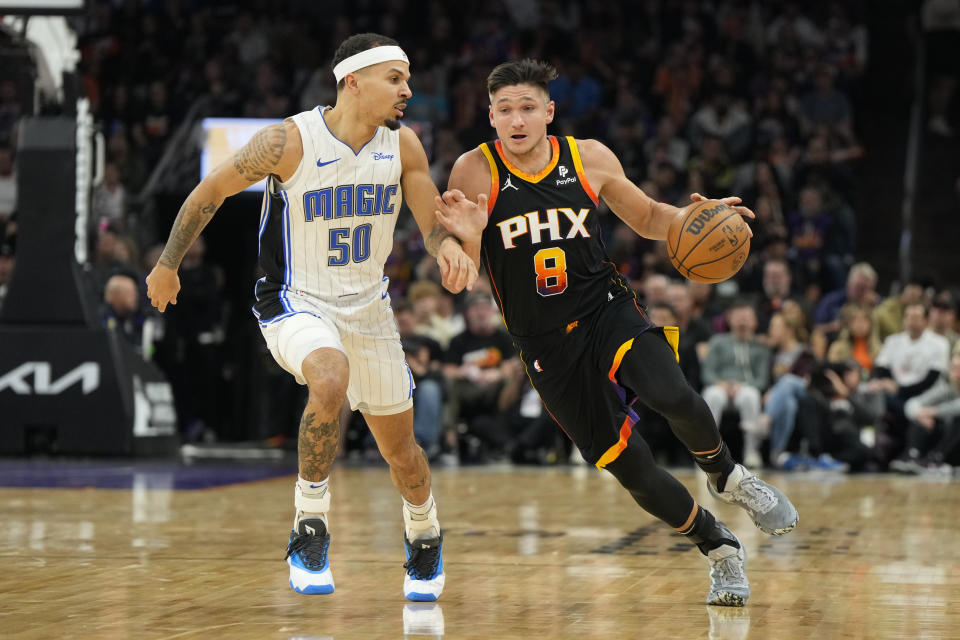 Phoenix Suns guard Grayson Allen (8) drives on Orlando Magic guard Cole Anthony during the first half of an NBA basketball game, Sunday, Dec. 31, 2023, in Phoenix. (AP Photo/Rick Scuteri)