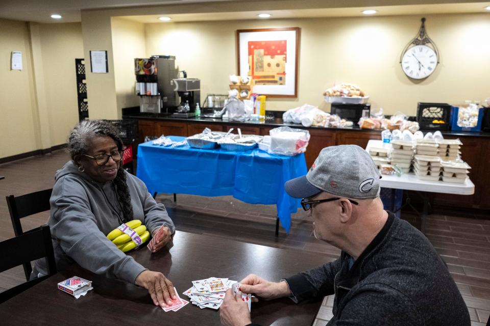 Jan 19, 2023; Westerville, Ohio, United States;  Linda Prysock, left, and James Holtz, both previous residents of Latitude Five25, play cards in the lobby of the hotel they are staying at during a dinnertime meal, which was sponsored by the Bethany Presbyterian Church. Mandatory Credit: Joseph Scheller-The Columbus Dispatch
