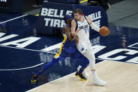 Dallas Mavericks' Luka Doncic (77) is defended by Indiana Pacers' Justin Holiday (8) during the first half of an NBA basketball game, Wednesday, Jan. 20, 2021, in Indianapolis. (AP Photo/Darron Cummings)