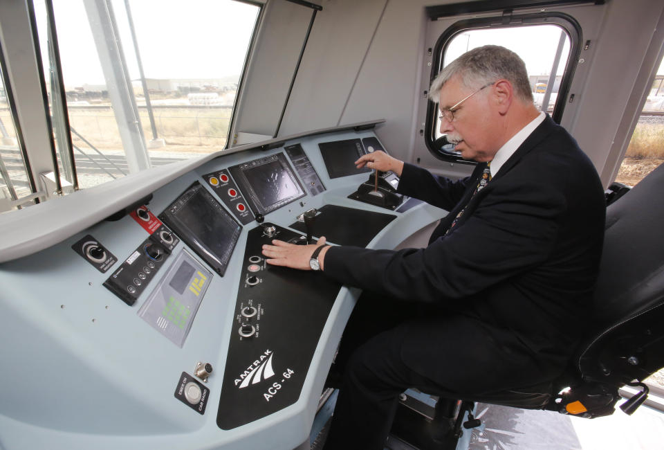 In this photo taken Saturday, May 11, 2013, Joseph Boardman, Amtrak President and CEO, left, looks over the controls of the new Amtrak Cities Sprinter Locomotive that was built by Siemens Rail Systems in Sacramento, Calif. The new electric locomotive will run on the Northeast intercity rail lines and replace Amtrak locomotives that have been in service for 20 to 30 years.(AP Photo/Rich Pedroncelli)