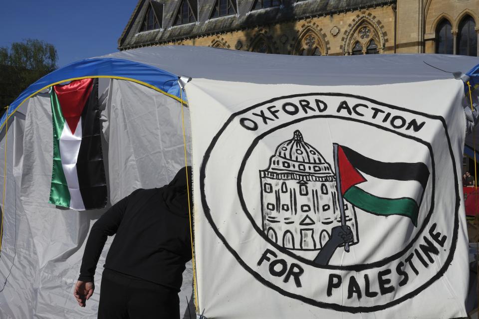 FILE - A pro-Palestinian student walks in a tent outside the Pitt Rivers Museum in Oxford, England, Thursday, May 9, 2024. Colleges and universities have long been protected places for free expression without pressure or punishment. But protests over Israel's conduct of the war in Gaza in its hunt for Hamas after the Oct. 7 massacre has tested that ideal around the world. The crackdowns are reviving memories of student-led protests during the American civil rights movement, the Vietnam War and the pro-democracy demonstrations in Beijing’s Tiananmen Square. (AP Photo/Kin Cheung, File)