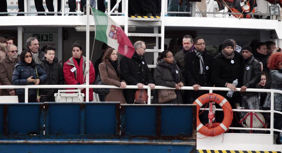 Relatives of the 32 victims of the Costa Concordia shipwreck, aboard a ferry approach the ship off the Tuscan Island Isola del Giglio, Italy, Sunday, Jan. 13, 2013. Survivors of the Costa Concordia shipwreck and relatives of the 32 people who died marked the first anniversary of the grounding Sunday. The first event of Sunday's daylong commemoration was the return to the sea of part of the massive rock that tore into the hull of the 112,000-ton ocean liner on Jan. 13, 2012 and remained embedded as the vessel capsized along with its 4,200 passengers and crew. (AP Photo/Gregorio Borgia)