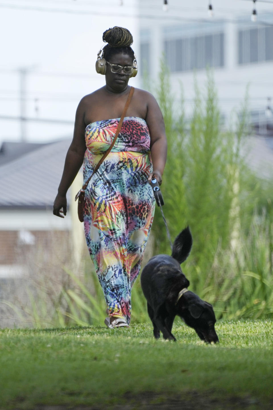 A Jackson, Miss., resident walks her dog through tree provided shade at Smith Park in downtown, Thursday, June 29, 2023. An oppressive heat wave blamed for at least 13 deaths in Texas and one in Louisiana is blanketing the South and the National Weather Service issued an excessive heat warning for parts of the Deep South on Friday, with a heat index expected to reach 115 degrees in several cities. (AP Photo/Rogelio V. Solis)