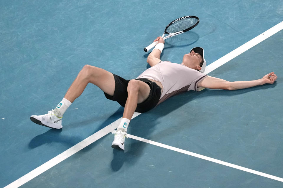 Jannik Sinner of Italy lays on the court after defeating Daniil Medvedev of Russia in the men's singles final at the Australian Open tennis championships at Melbourne Park, in Melbourne, Australia, Sunday, Jan. 28, 2024. (AP Photo/Louise Delmotte)