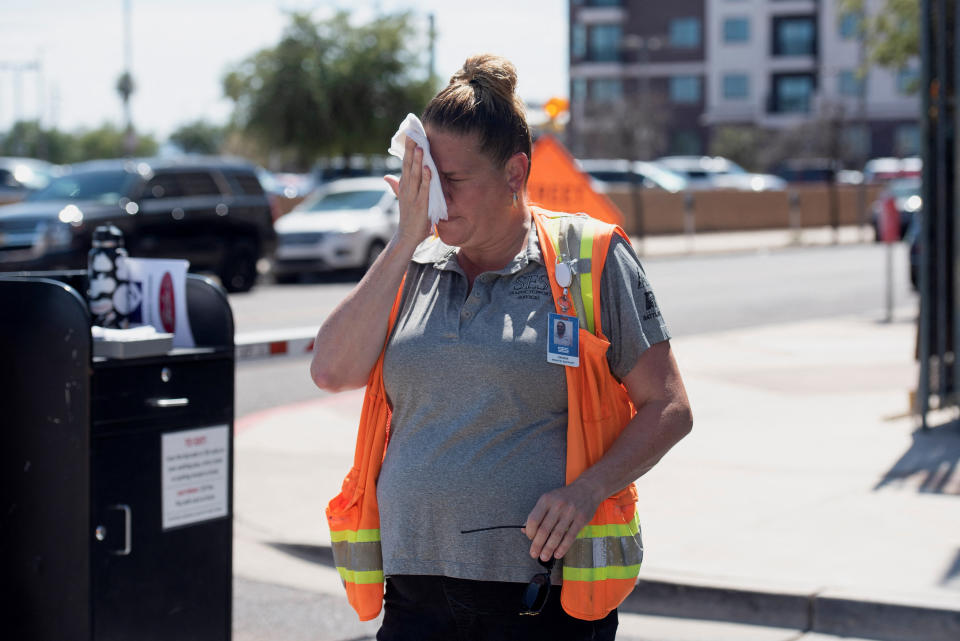 Vangie Jacobo wipes her face with a wet rag while working outside in 106 degree heat in Phoenix, Arizona, U.S. July 23, 2022.  REUTERS/Rebecca Noble
