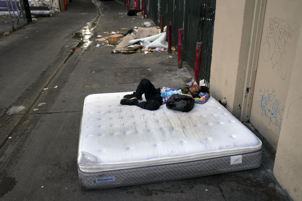 FILE - A homeless man sleeps on a discarded mattress in Los Angeles, July 21, 2022. Over the objections of homeless advocates, the Los Angeles City Council two years ago passed a broad anti-camping measure that was billed as a compassionate approach to get people off the streets and restore access to public spaces in the city with the nation's second-largest homeless population. (AP Photo/Jae C. Hong, File)