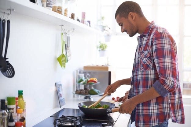 A man cooks himself dinner on the stove