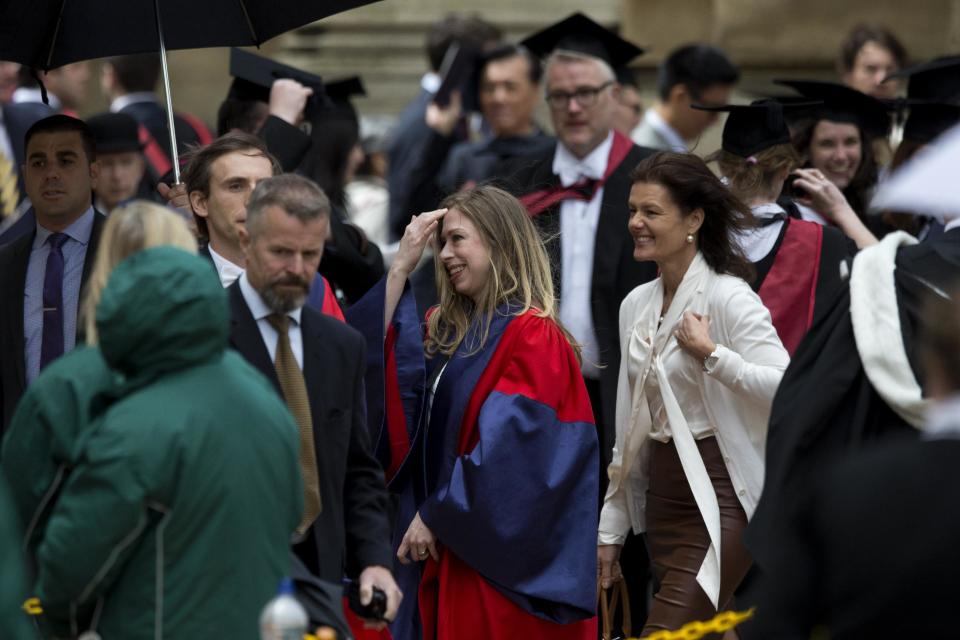 Chelsea Clinton, center, walks to pose for a formal photograph with her husband Marc Mezvinsky and her parents former U.S. President Bill Clinton and former Secretary of State Hillary Rodham Clinton after they attended Chelsea's Oxford University graduation ceremony at the Sheldonian Theatre in Oxford, England, Saturday, May 10, 2014. Chelsea Clinton received her doctorate degree in international relations on Saturday from the prestigious British university. Her father was a Rhodes scholar at Oxford from 1968 to 1970. The graduation ceremony comes as her mother is considering a potential 2016 presidential campaign. (AP Photo/Matt Dunham)