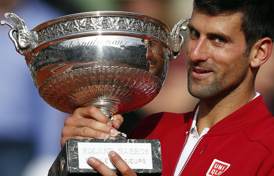 FILE - Serbia's Novak Djokovic holds the trophy after winning the final of the French Open tennis tournament against Britain's Andy Murray in four sets, at the Roland Garros stadium in Paris, France, June 5, 2016. Djokovic will be trying to set the record for the most Grand Slam singles trophies won by a man when he goes for what would be No. 23 against Casper Ruud in the French Open final on Sunday, June 11, 2023. Djokovic enters that match with 22, tied with his rival Rafael Nadal. Roger Federer, who announced his retirement last year, is next with 20. (AP Photo/Christophe Ena, File)