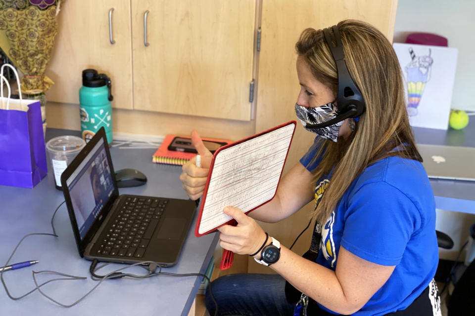 Image: Nikki Musser, an education assistant, monitors first graders attending class at Witch Hazel Elementary remotely. The school operated on a hybrid schedule last year. 