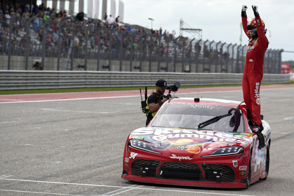Kyle Busch stands on his car as he celebrates after winning the NASCAR Xfinity Series auto race at the Circuit of the Americas in Austin, Texas, Saturday, May 22, 2021. (AP Photo/Chuck Burton)