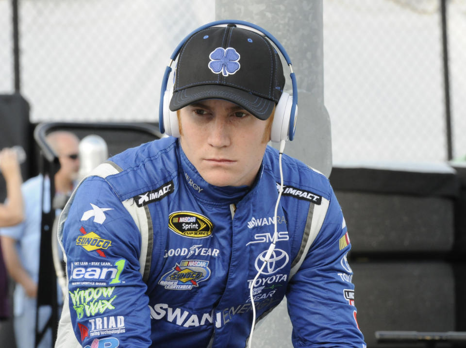 FILE - In this April 11, 2014 file photo, Cole Whitt waits before qualifying for a NASCAR Sprint Cup series auto race at Darlington Speedway in Darlington, S.C. Swan Racing's future is on the rocks and the two-car team is reviewing its ability to compete in NASCAR. Whitt drives the No. 26 Toyota Camry and Parker Kligerman drives the No. 30 Toyota Camry for Swan in the Sprint Cup series. Swan Racing is owned by Brandon Davis, the CEO of independent oil and gas company Swan Energy. (AP Photo/Mike McCarn, File)