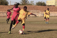 In this Wednesday, Dec. 11, 2019 photo, Sudanese al-Difaa, in yellow, and al-Sumood women teams play in Omdurman, Khartoum's twin city, Sudan. The women's soccer league has become a field of contention as Sudan grapples with the transition from three decades of authoritarian rule that espoused a strict interpretation of Islamic Shariah law. (AP Photo)