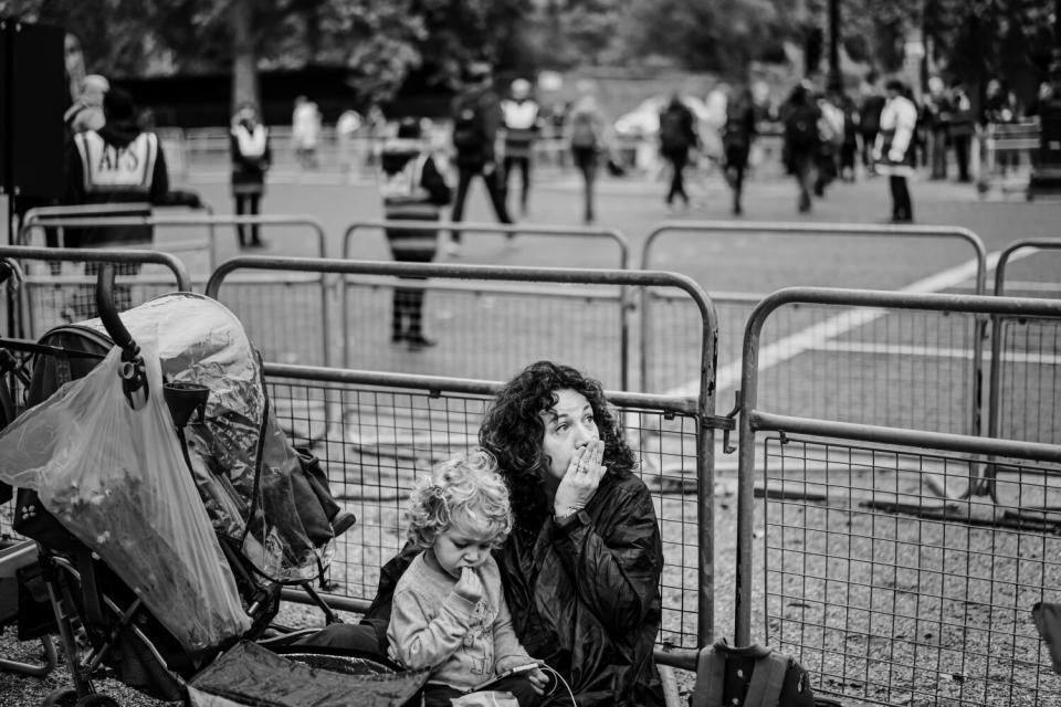 Annabel Haken, and her son, Thomas, 4, sit along the procession route.