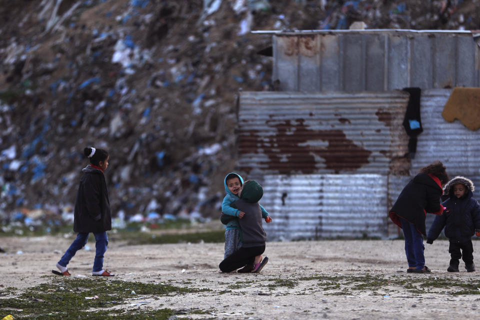 Palestinian children play outside their homes during a cold weather spell in a slum on the outskirts of the Khan Younis refugee camp, southern Gaza Strip, Wednesday, Jan. 19, 2022. (AP Photo/Khalil Hamra)