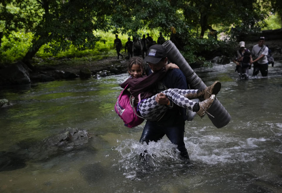 Venezuelan migrants wade a river during their journey across the Darien Gap from Colombia into Panama hoping to reach the U.S. on Saturday, Oct. 15, 2022. (AP Photo/Fernando Vergara)