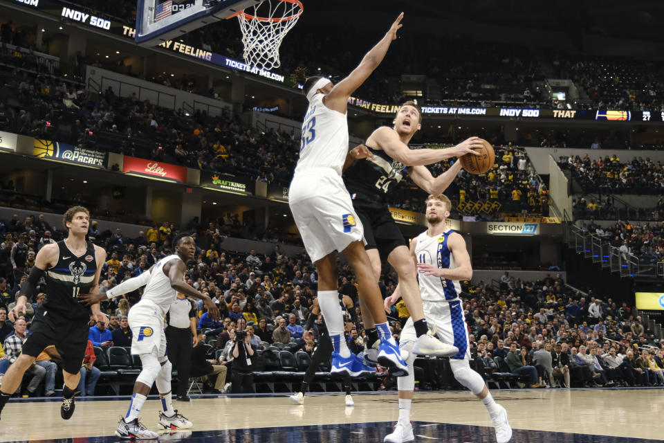 Milwaukee Bucks guard Pat Connaughton (24) shoots around Indiana Pacers center Myles Turner (33) during the second half of an NBA basketball game in Indianapolis, Wednesday, Feb. 12, 2020. The Pacers won 118-111. (AP Photo/AJ Mast)