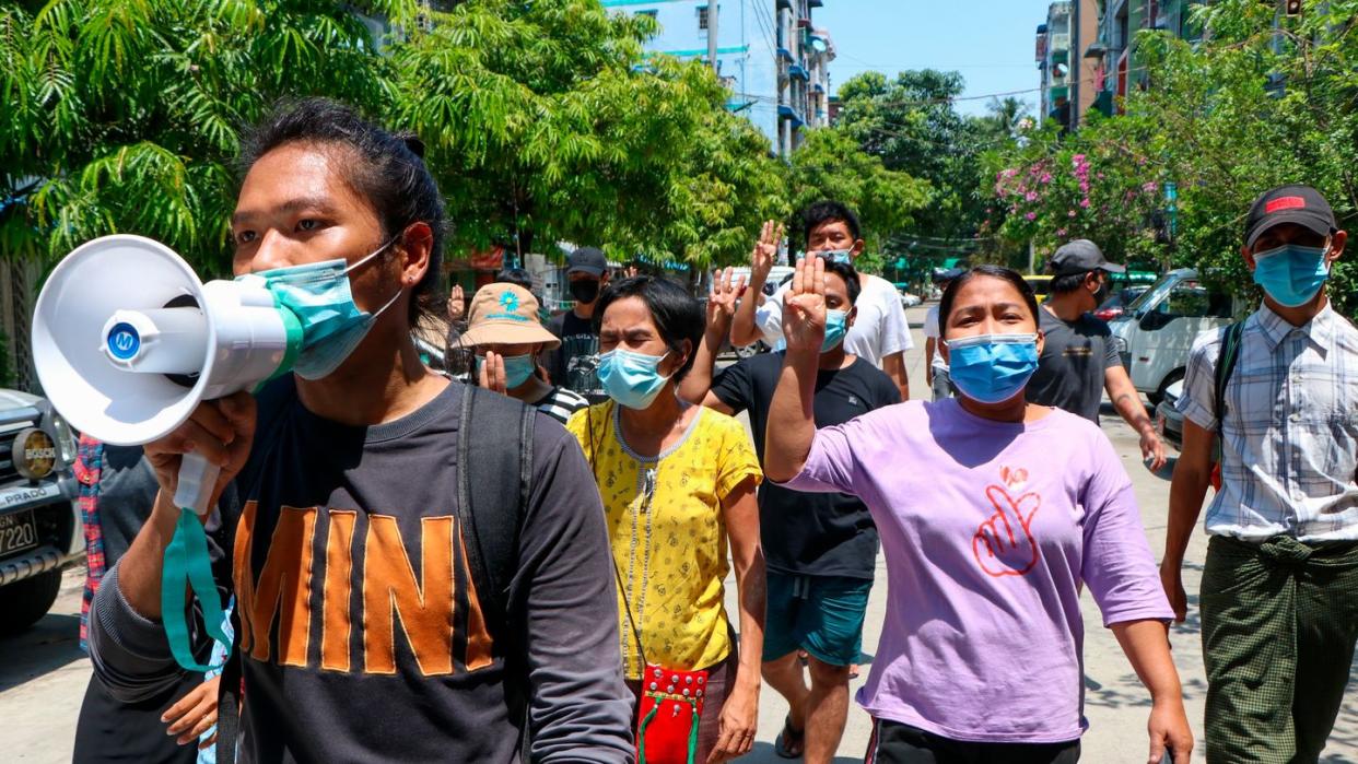 Menschen zeigen bei einer Demonstration in Yangon den Drei-Finger-Gruß als Zeichen des Widerstands.