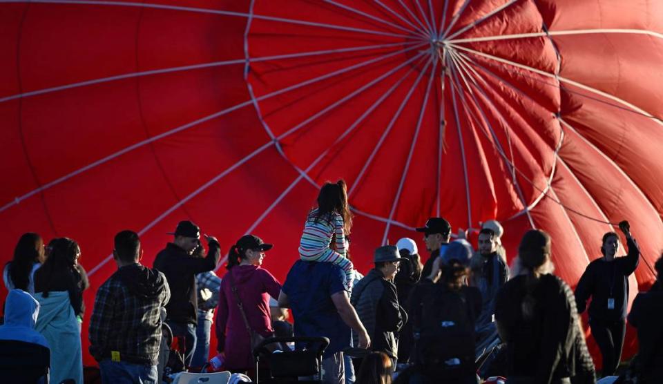 People watch as a balloon is inflated during the Skies the Limit Ceres Balloon Festival at River Bluff Regional Park in Ceres, Calif., Saturday, June 15, 2024.