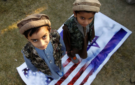 Children stand on U.S. and Israeli flags during a protest following U.S. President Donald Trump's announcement that he has recognized Jerusalem as Israel's capital, in Islamabad, Pakistan December 7, 2017. REUTERS/Caren Firouz