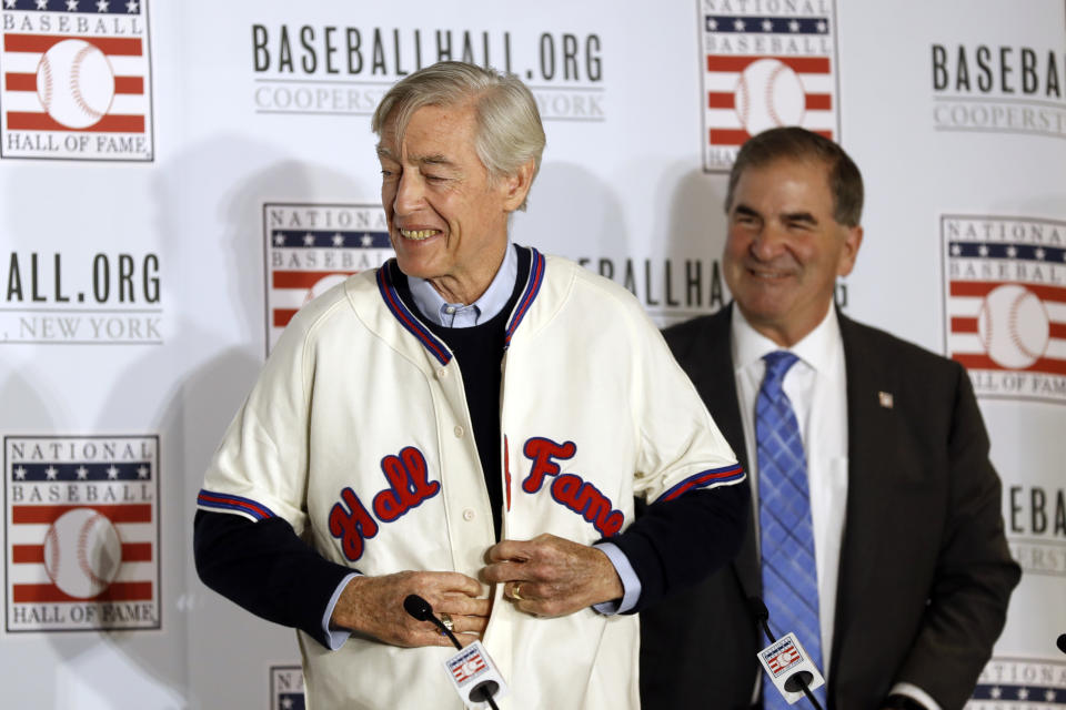 Former St. Louis Cardinals catcher Ted Simmons buttons a Hall of Fame jersey as National Baseball Hall of Fame President Tim Mead looks on, right, during the Major League Baseball winter meetings Monday, Dec. 9, 2019, in San Diego. Simmons was elected into the Hall of Fame Sunday. (AP Photo/Gregory Bull)