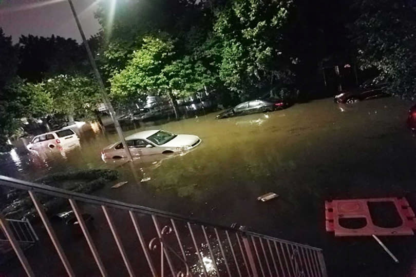 驟降的暴雨讓路面被積水淹沒，停在路邊的車子也都泡在水中無法移動。（圖／翻攝自Twitter）