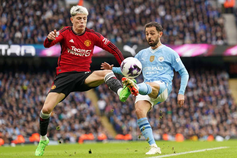 Manchester United's Alejandro Garnacho (L) and Manchester City's Bernardo Silva battle for the ball during the English Premier League soccer match between Manchester City and Manchester United at the Etihad Stadium. Mike Egerton/PA Wire/dpa
