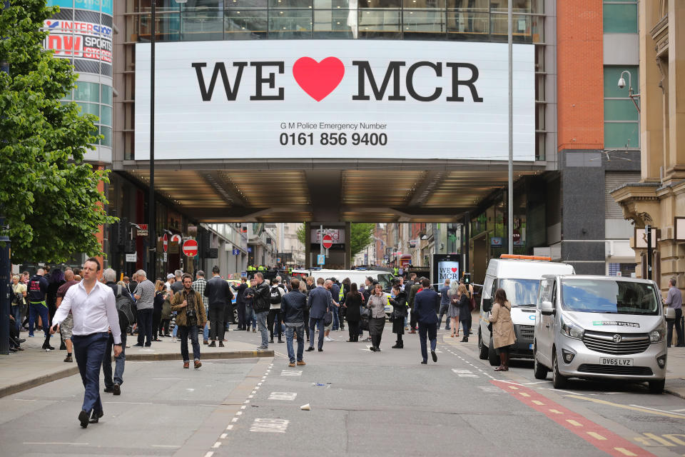 Crowds of people wait outside after police evacuated the Arndale Centre in Manchester.&nbsp;