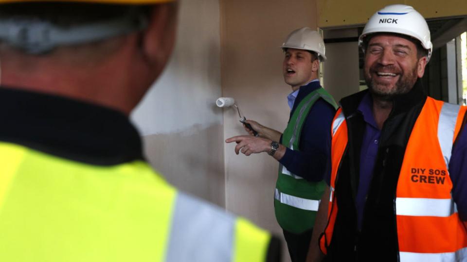 Prince William (C) jokes with presenter Nick Knowles (R) as he joins the crew of TV show DIY SOS