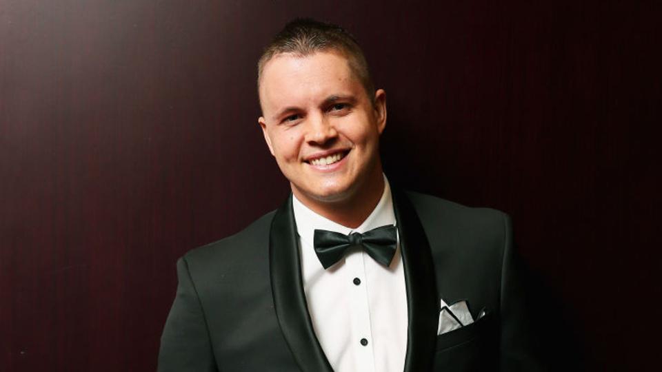 Johnny Ruffo wearing a tuxedo and smiling. 