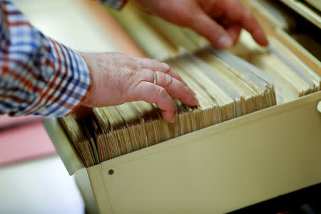 An employee works on record cards of the former East German Ministry for State Security (MfS), known as the Stasi, while he poses during a tour at the central archives office in Berlin, Germany, March 12, 2019. Picture taken March 12, 2019. REUTERS/Fabrizio Bensch