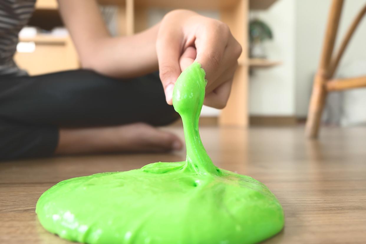 Finger pulling green slime off of the floor