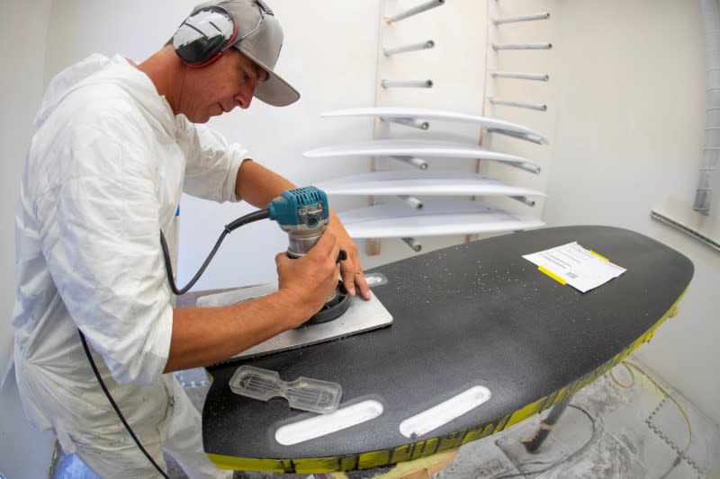 FILE PHOTO: James Black works on a soft INT surfboard at the INT surfboard factory in Carlsbad, California