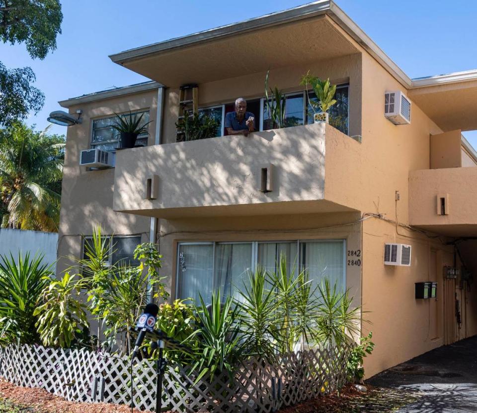 Con una unidad de aire acondicionado ya instalada en su apartamento, Julio Banegas un vecino de 2842 NW 10th Avenue en Miami, mira desde su balcón mientras los funcionarios del Condado Miami-Dade se preparan para dar una conferencia de prensa para anunciar una iniciativa del Condado Miami-Dade para financiar cientos de nuevas unidades de aire acondicionado para los apartamentos de vivienda pública, el 28 de noviembre de 2022.