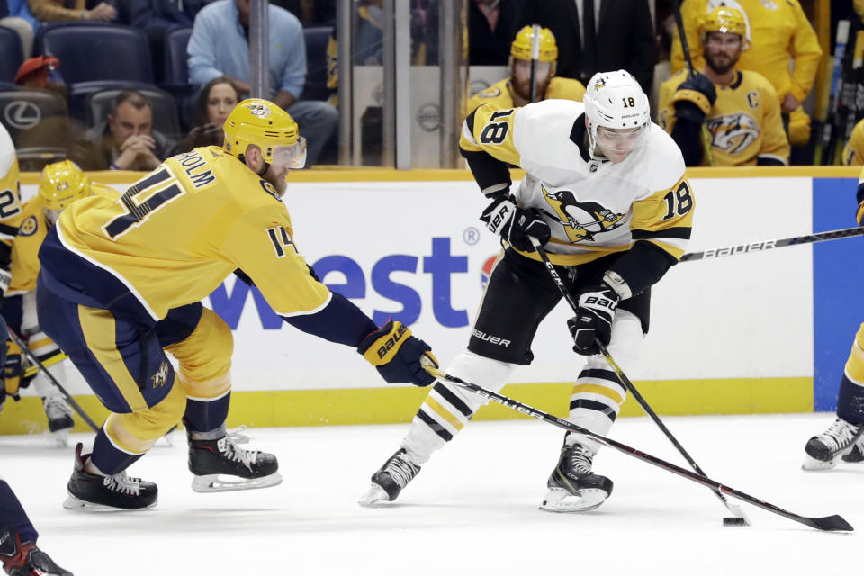 Nashville Predators defenseman Mattias Ekholm (14), of Sweden, tries to slow Pittsburgh Penguins center Alex Galchenyuk (18) during the first period of an NHL hockey game Friday, Dec. 27, 2019, in Nashville, Tenn. (AP Photo/Mark Humphrey)