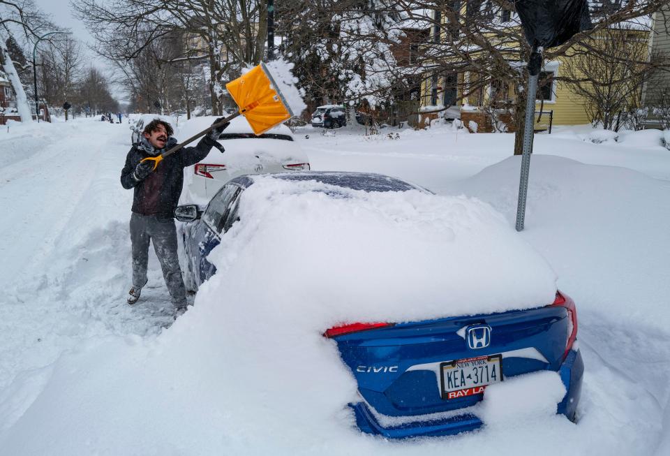 Christian Parker of Buffalo, N.Y., shovels out his car in the Elmwood Village neighborhood after a massive snow storm blanketed the city.