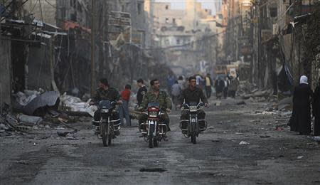 Security personnel loyal to Syria's President Bashar al-Assad ride motorcycles along a deserted street in Hujaira town, south of Damascus November 21, 2013. REUTERS/ Alaa Al-Marjani