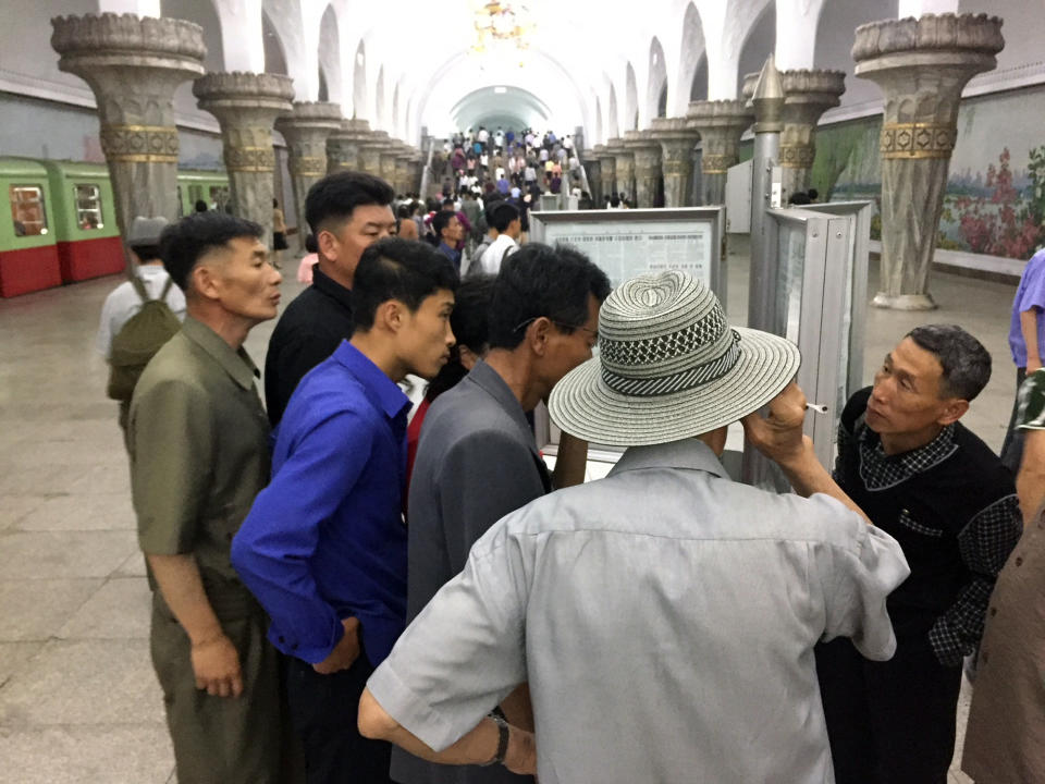 <p>Commuters read the news of North Korean leader Kim Jong Un’s arrival in Singapore on Monday, ahead of his summit with President Trump. (Photo: Eric Talmadge/AP) </p>